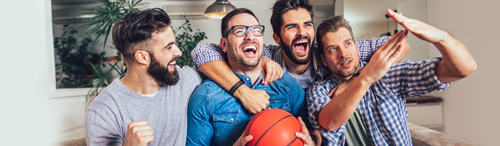 four guys enjoying basketball game on television