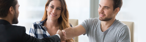 young couple shaking hands with real estate agent illustrating personal touch for first time homebuyers