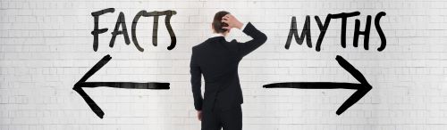 man in suit facing subway wall with the words Facts and Myths with arrows in opposite directions under the words